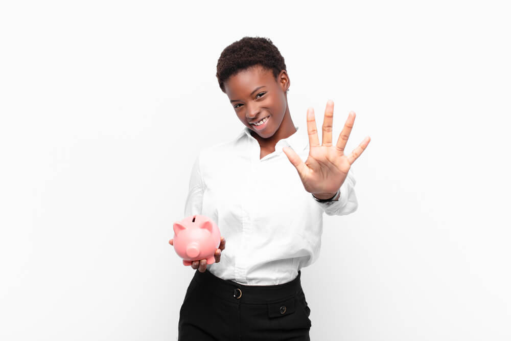 woman holding pig bank and has hand out for 5