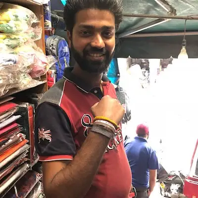 man holding up his arm to show his friendship bracelet