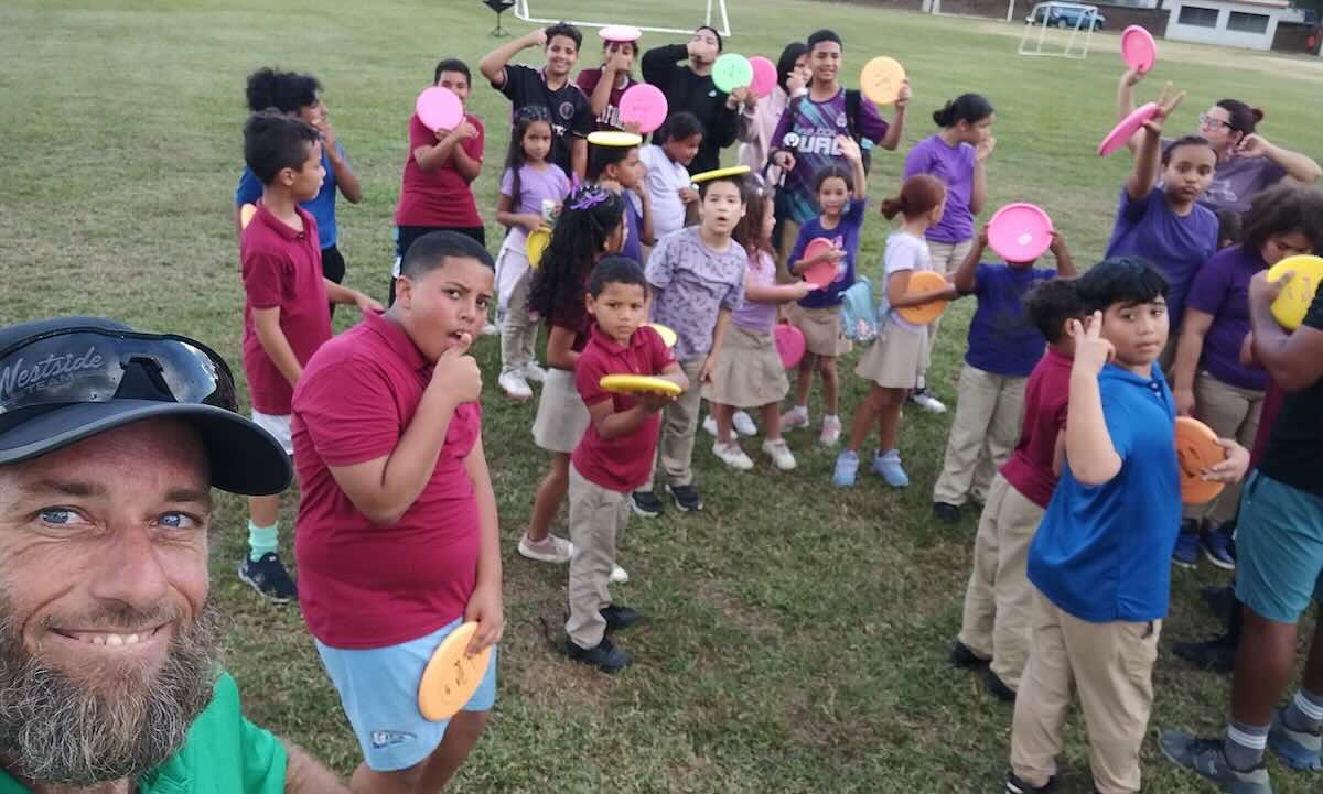 A group of school children holding discs