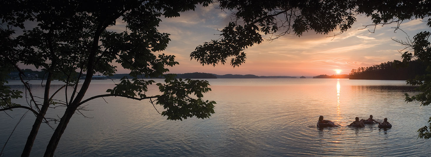 Group of people swimming at Alex City Alabama Lake Martin at sunset