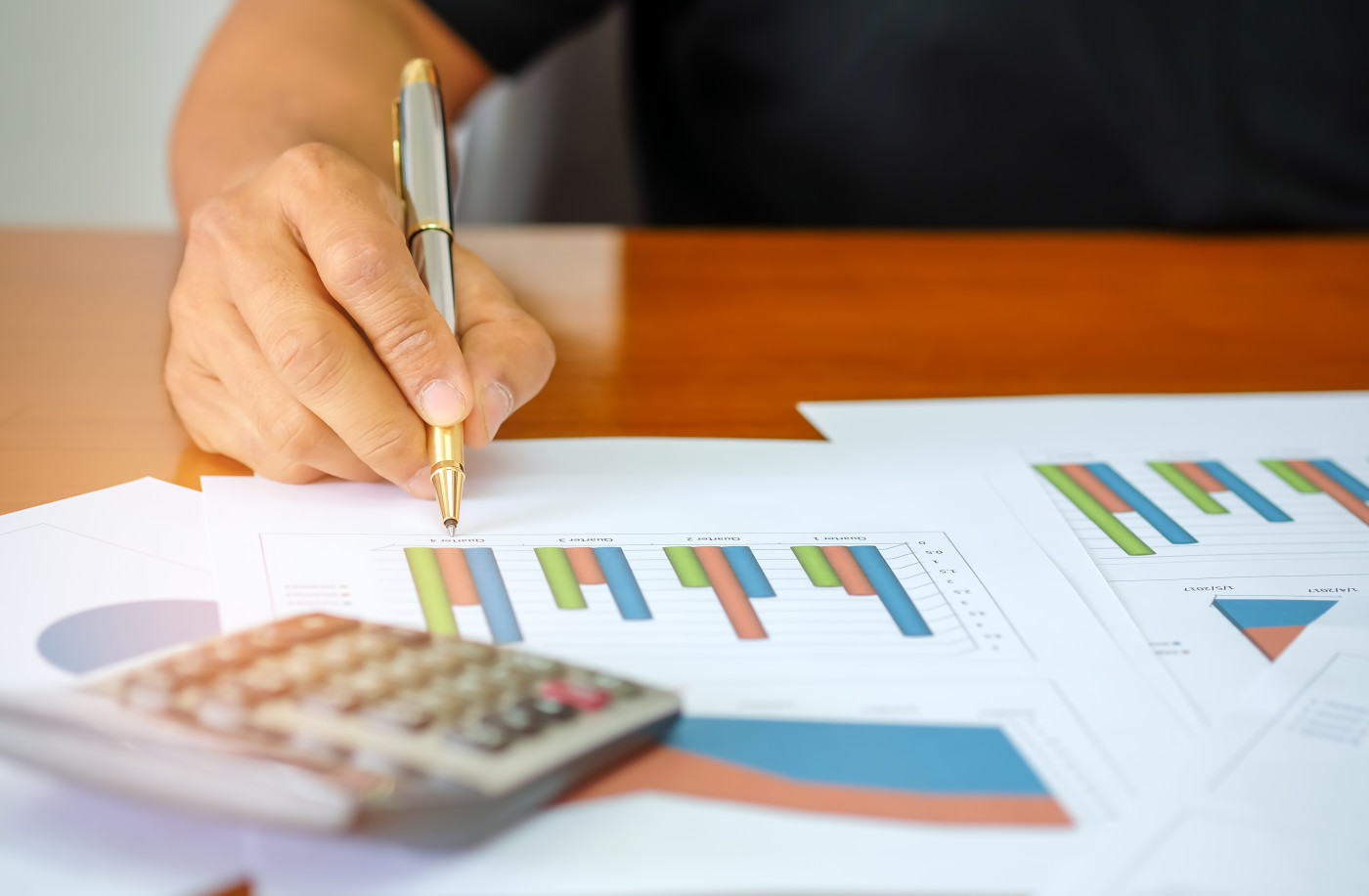 Men are using a calculator to analyze income data