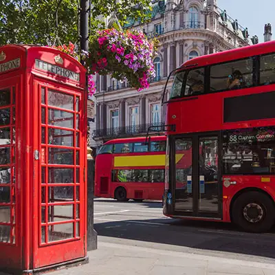 London, England tour bus passing a telephone booth.