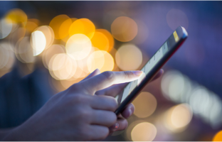 Person holding a mobile device with a blurred background