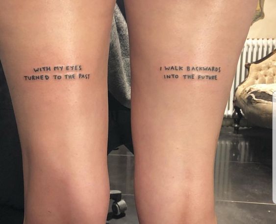quote tattoo on woman's legs