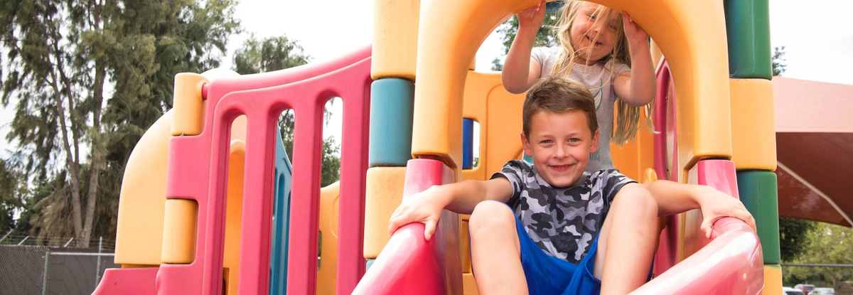 Two Children playing on an outdoor play structure