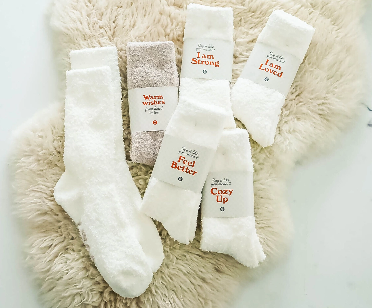 6 pairs of socks lay atop a fuzzy rug