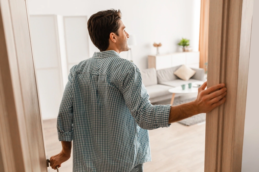 Man opening door to his living room