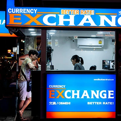 Man standing near counter of currency exchange.