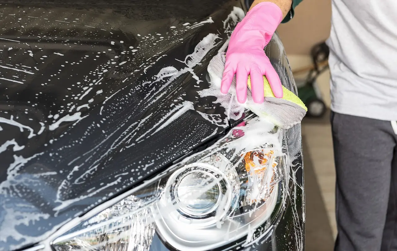 Recubrir el coche con cera líquida. concepto de lavado de autos