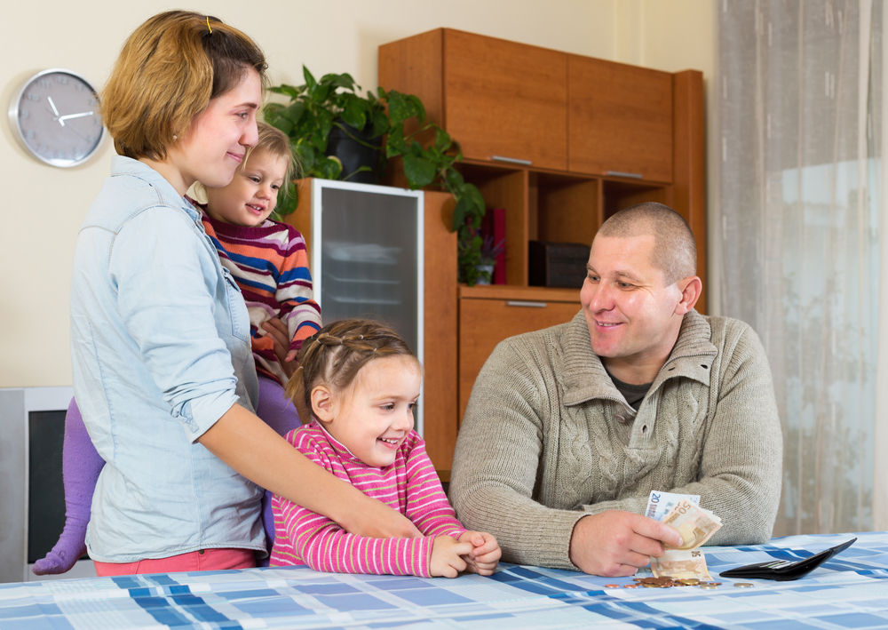 Family counting cash at the dining table.