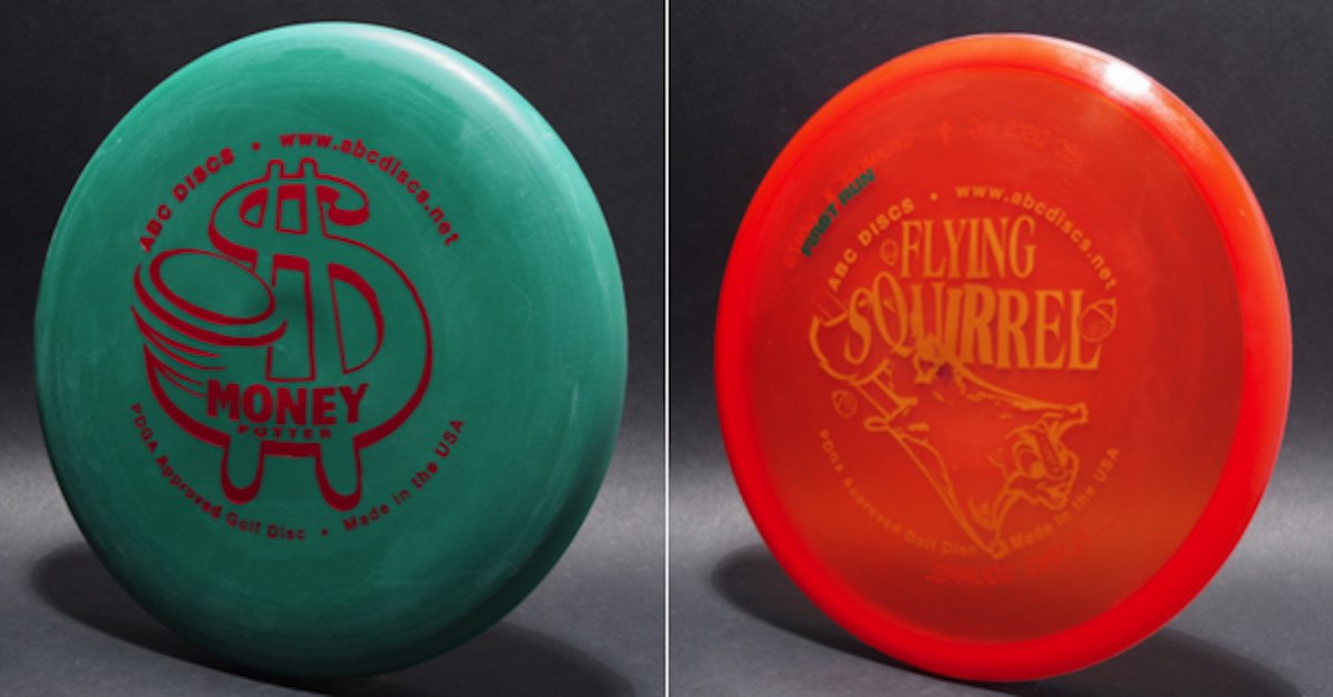 Two discs. One green with a dollar sign stamp, the other red with gold lettering saying "Flying squirrel"