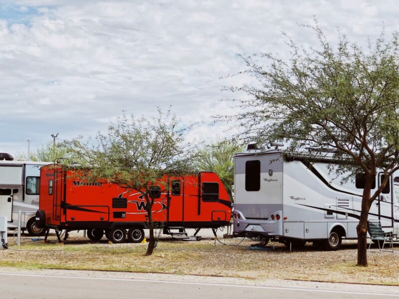 A red rv parked next to a white rvDescription automatically generated