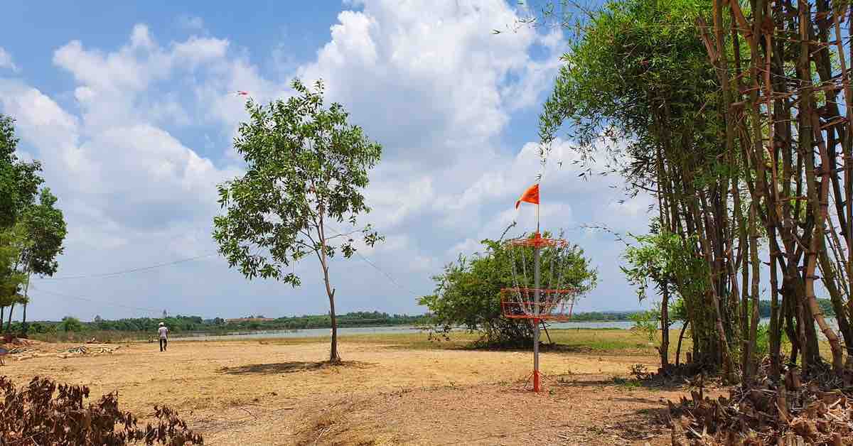 A disc golf basket with water in background