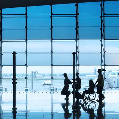 Person on wheelchair with family at airport.