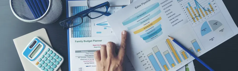 hand and spreadsheets on table