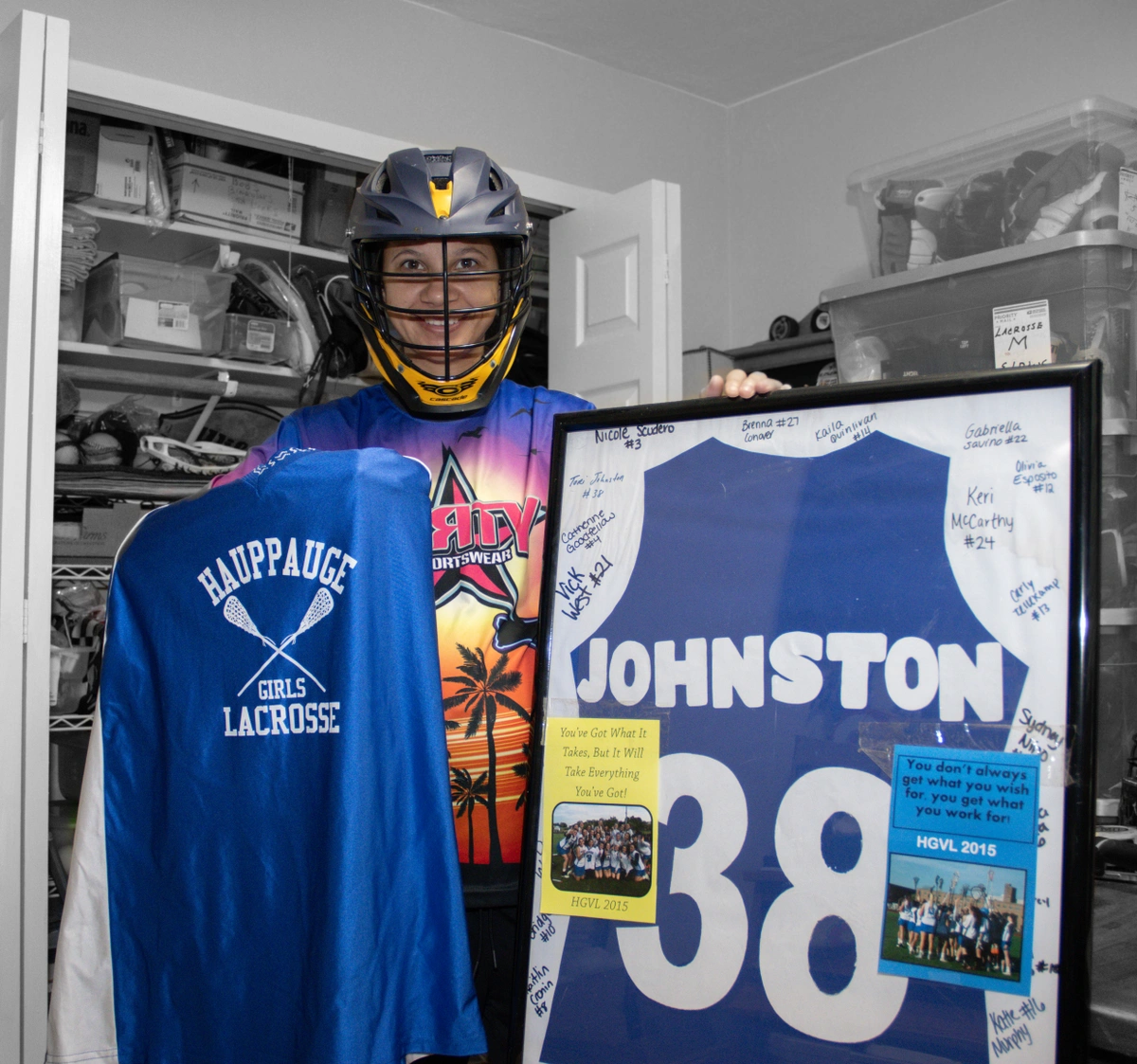 Tori Johnston holding up lacrosse jerseys 