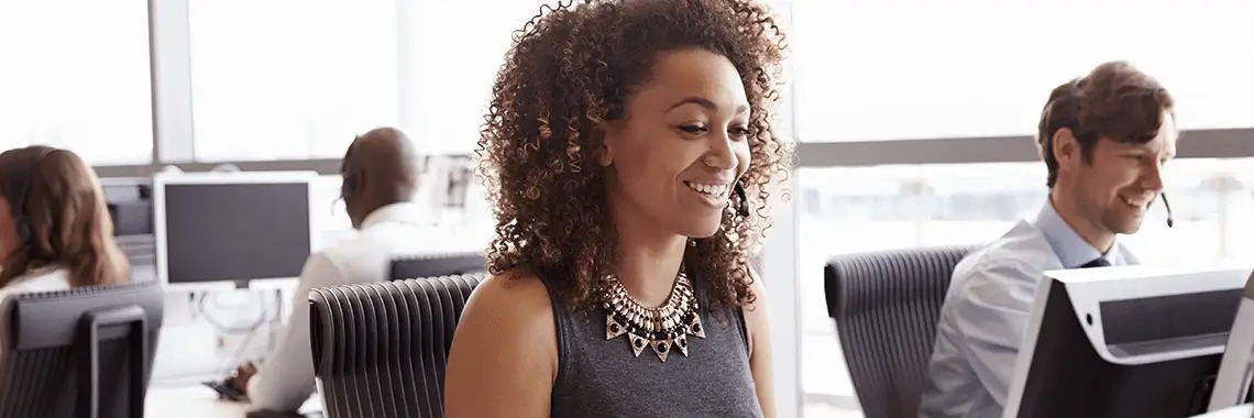 Woman smiling at her desk.