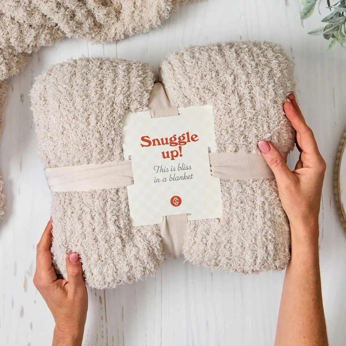 A cozy comfort throw is bundled with a label that says "Snuggle up!"