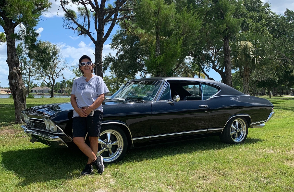 Woman standing in front of a ‘68 Chevelle SS