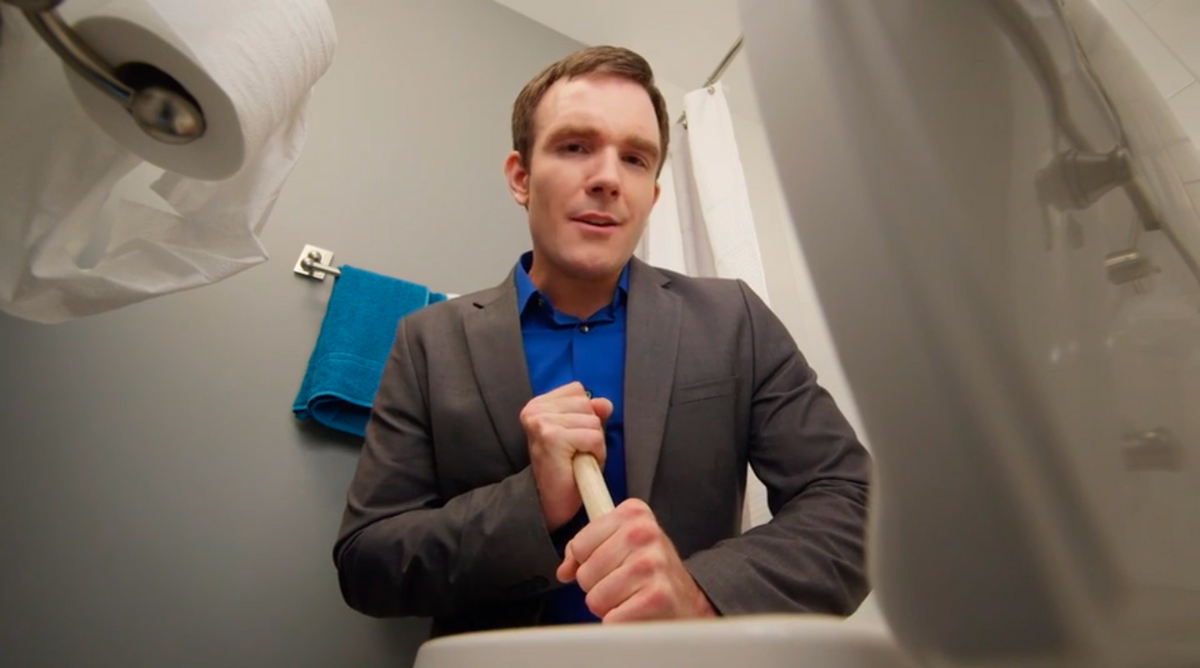 Man in suite cleaning toilet