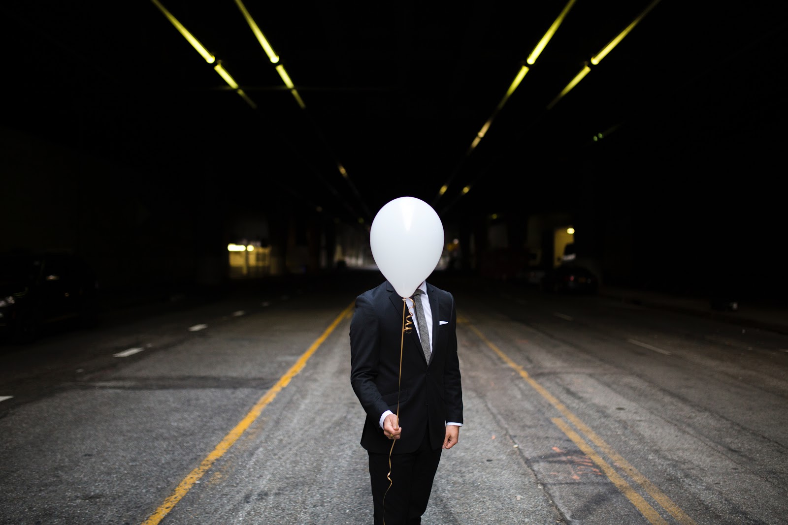 man holding white balloon
