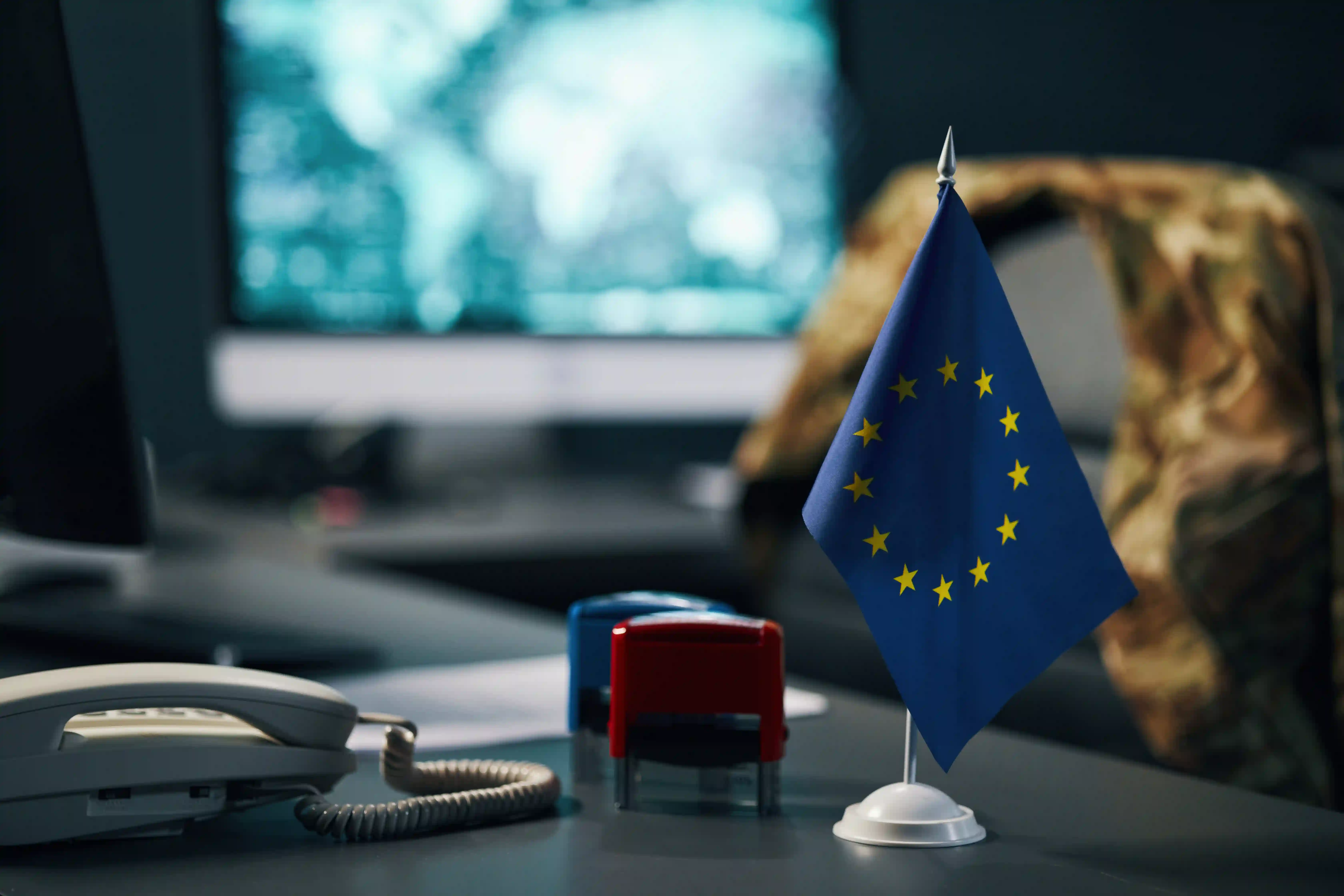 European Union flag on office desk representing global compliance and regulatory requirements