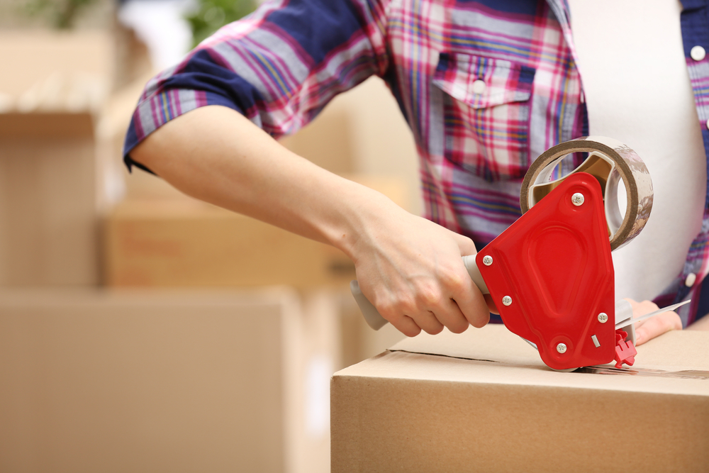 Person packaging moving boxes