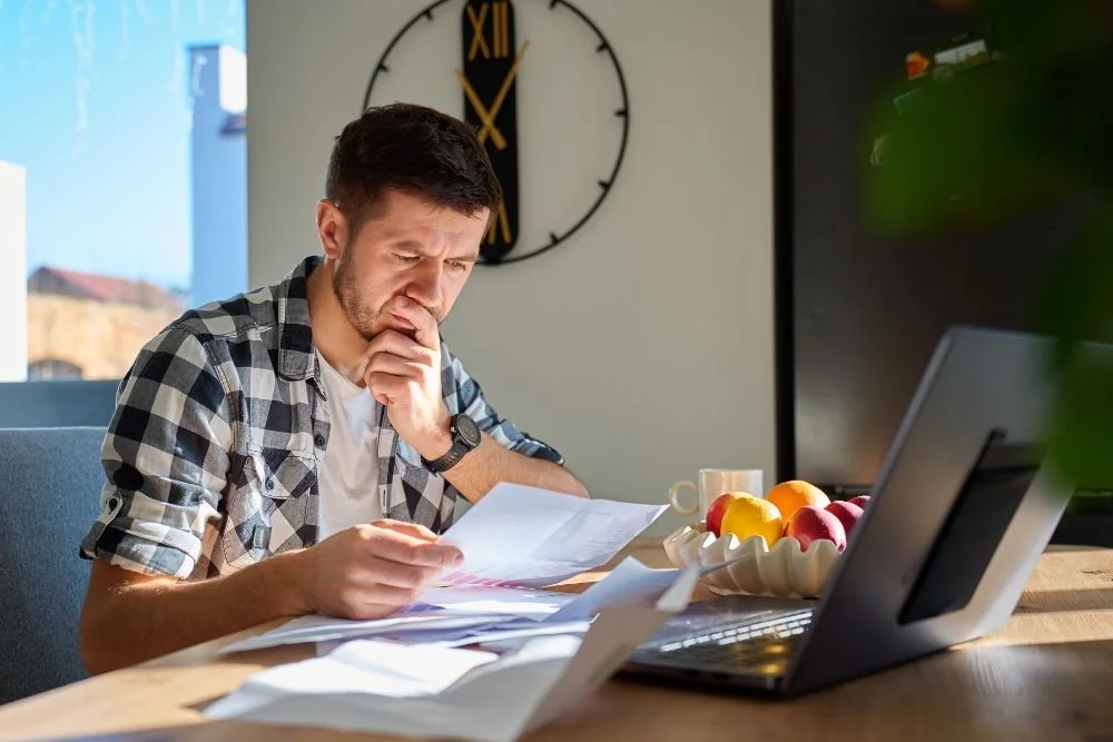Man concerned about sperm banking storage costs while reviewing bills.