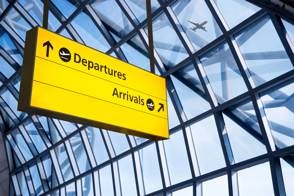 Airport terminal sign displaying directions to departures and arrivals