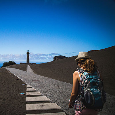 Woman hiking to a lighthouse.