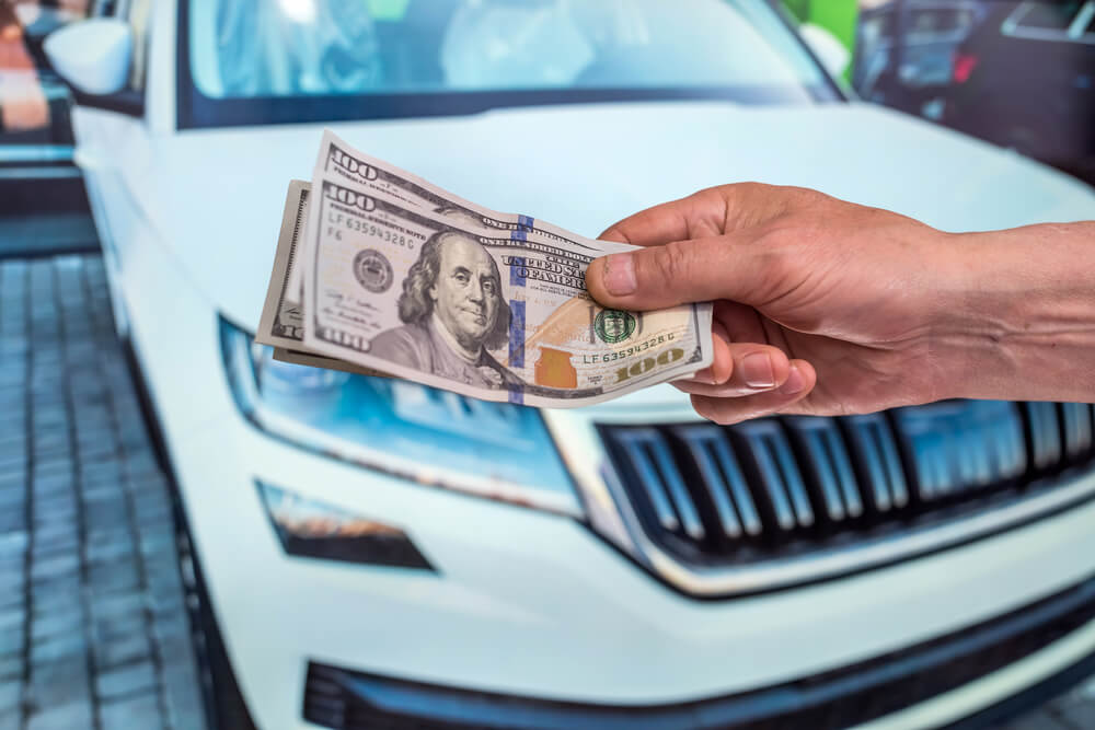 person holding car title loan cash