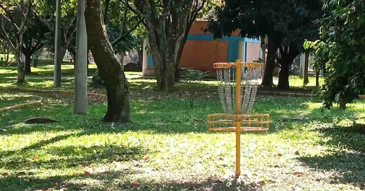 Yellow disc golf basket in a city park