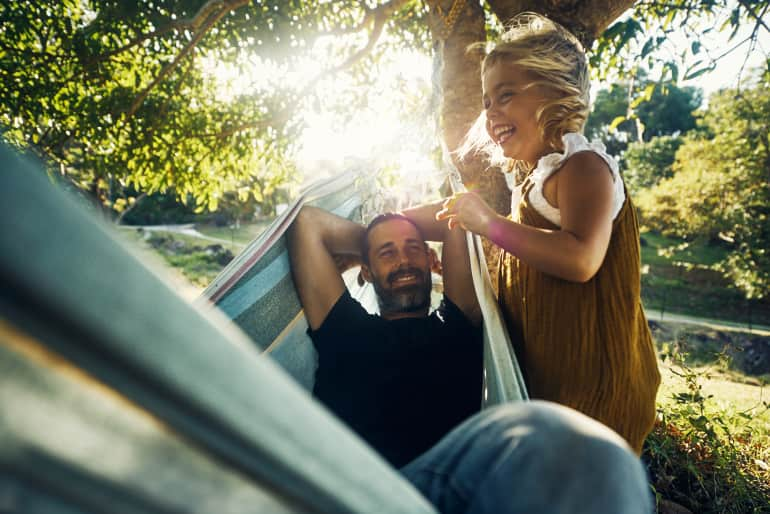 dad and daughter laughing in hammock