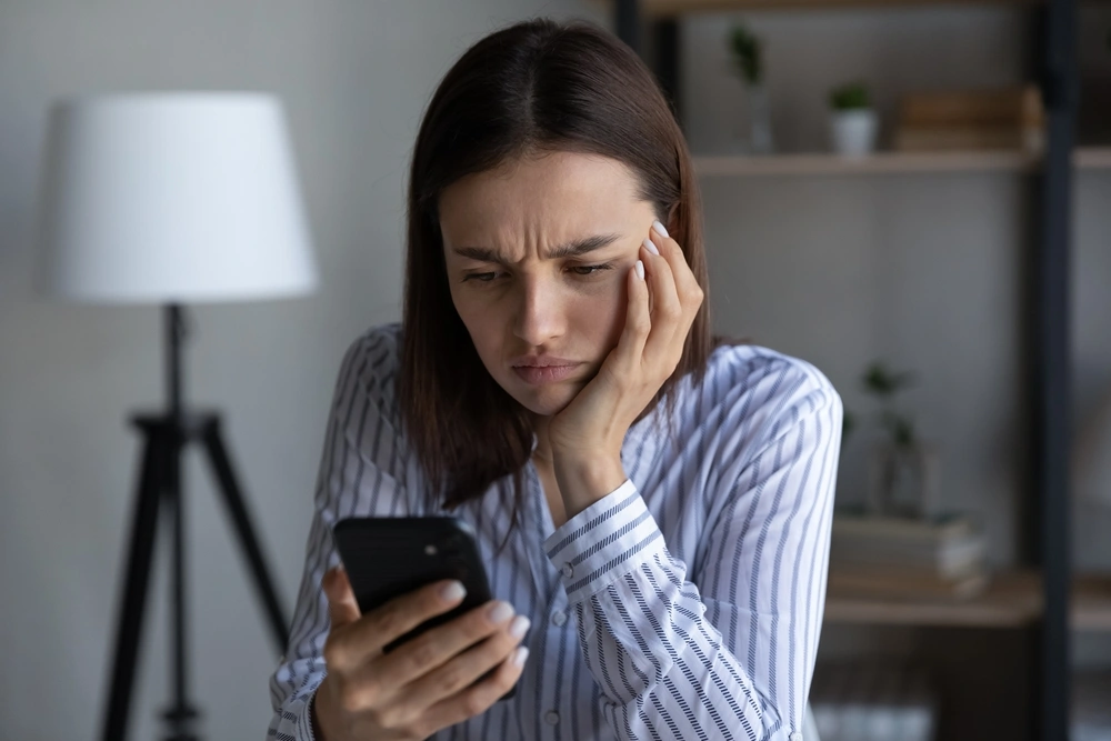 Woman looking at her smartphone, worried