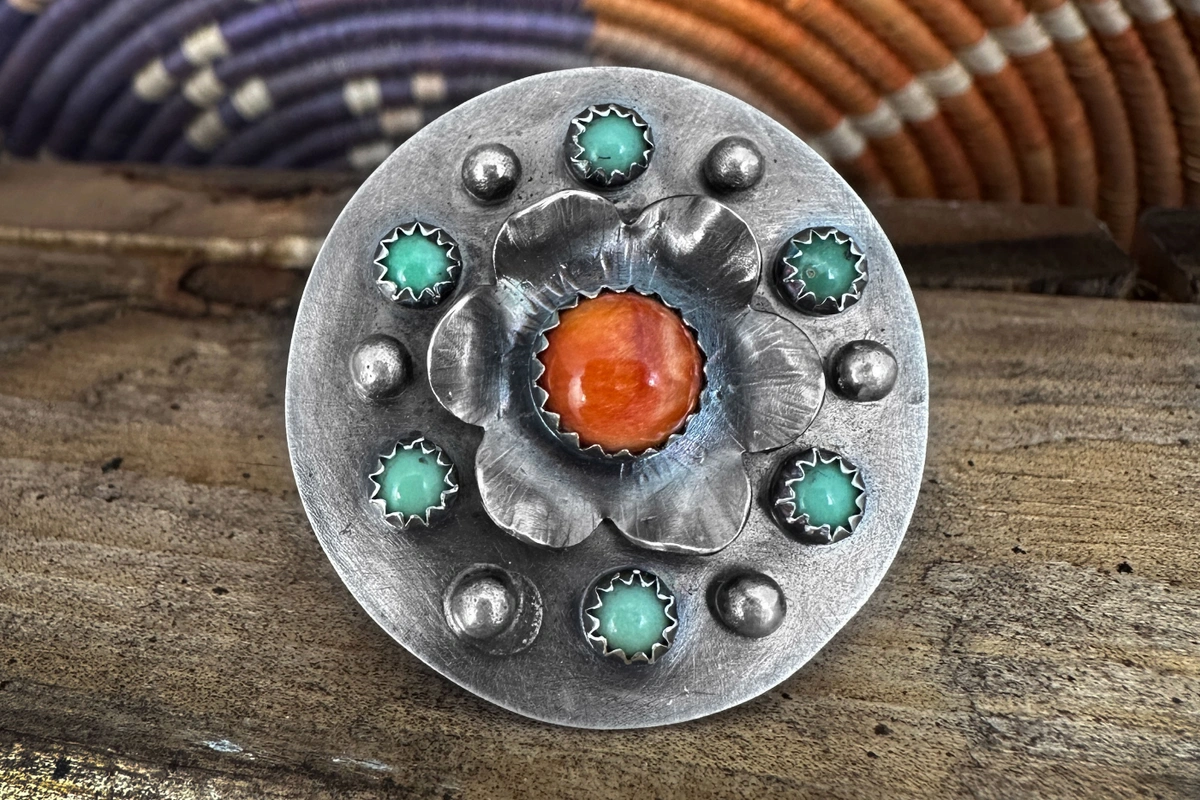 western style ring with spiny oyster center stone on a flower with turquoise and silver balls around it