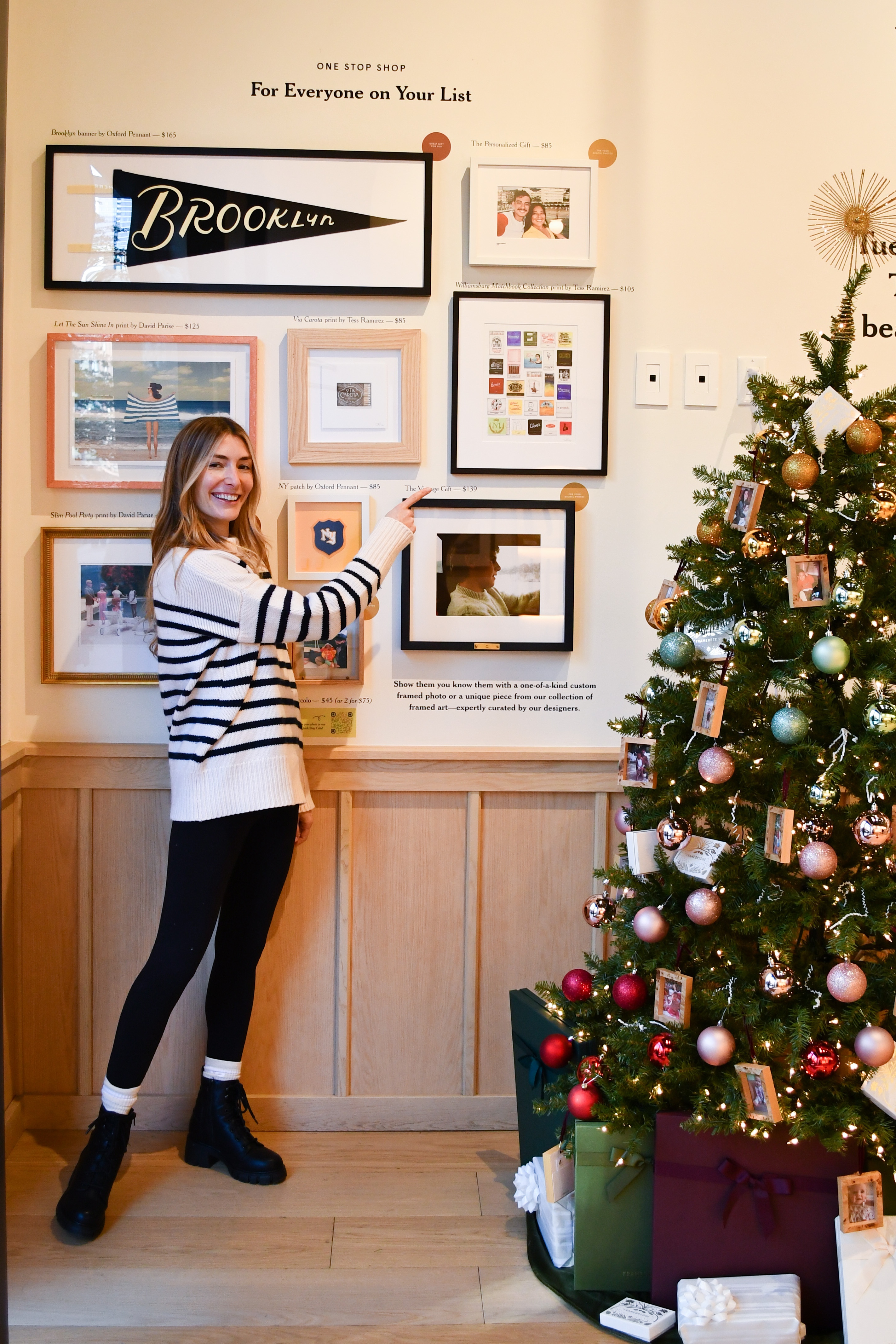 woman pointing to framed matchbooks print in store