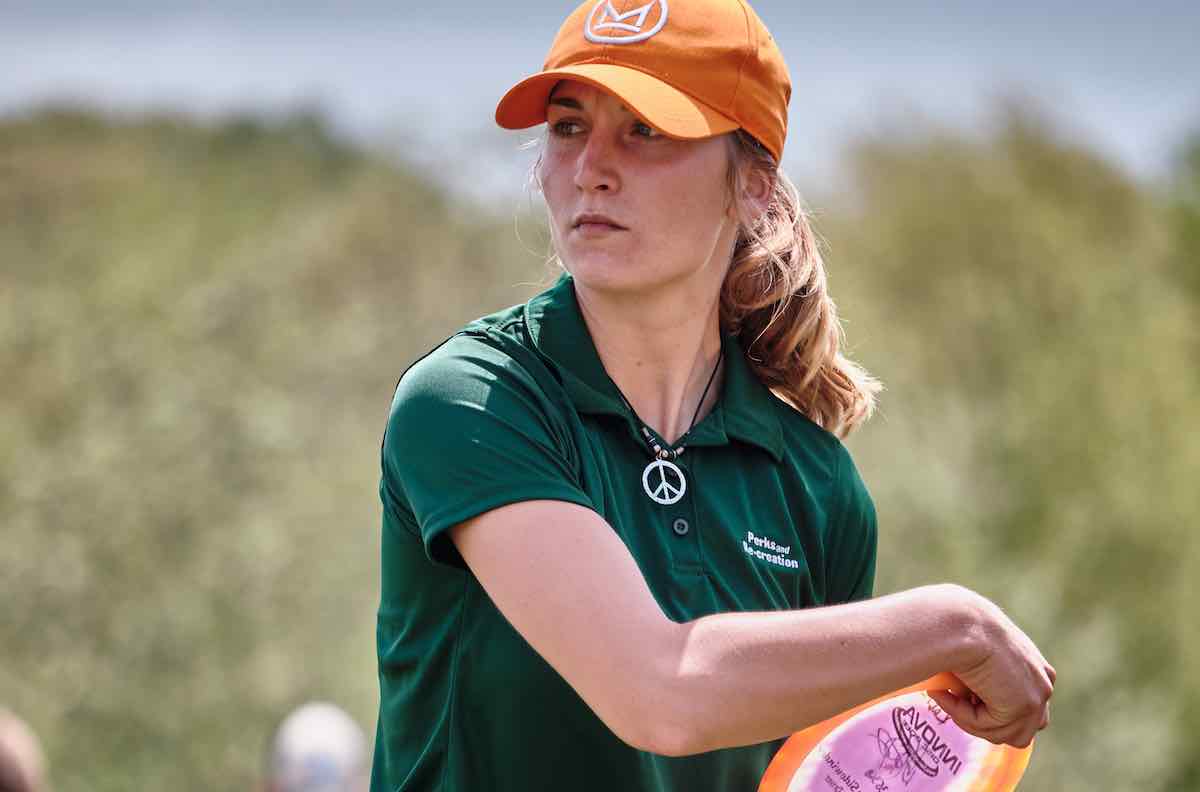 A young woman prepares to throw a disc golf disc