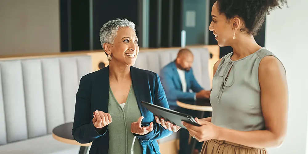 two women speaking in an office environment