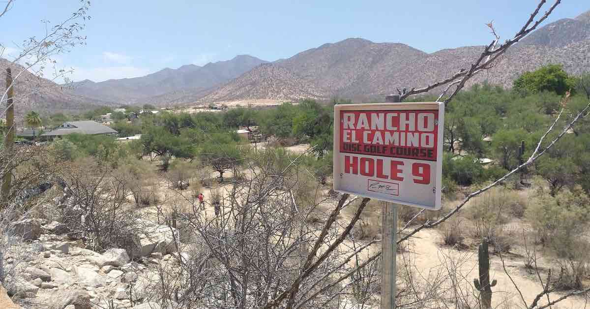 A disc golf tee sign in a mountainous, desert environment