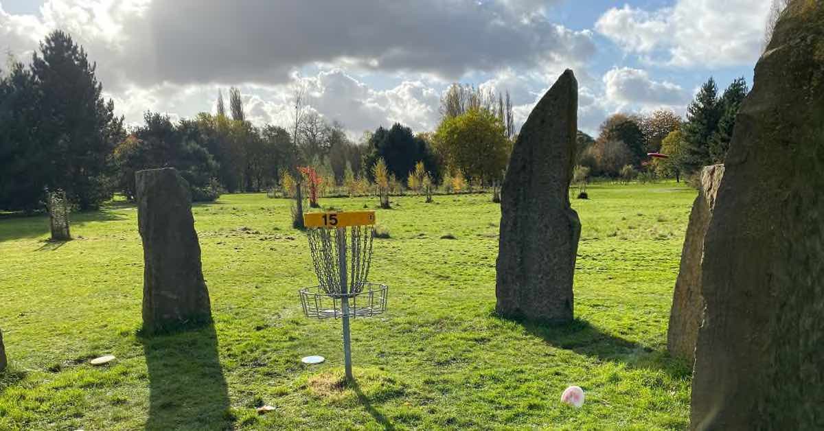 Disc golf basket surrounded by stones similar to Stonehenge