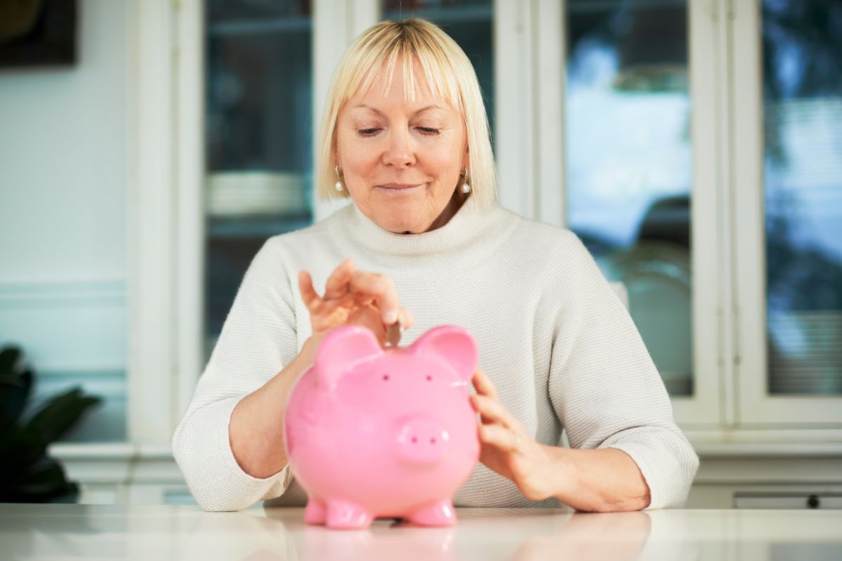 woman earning money in retirement and putting it into a piggy bank