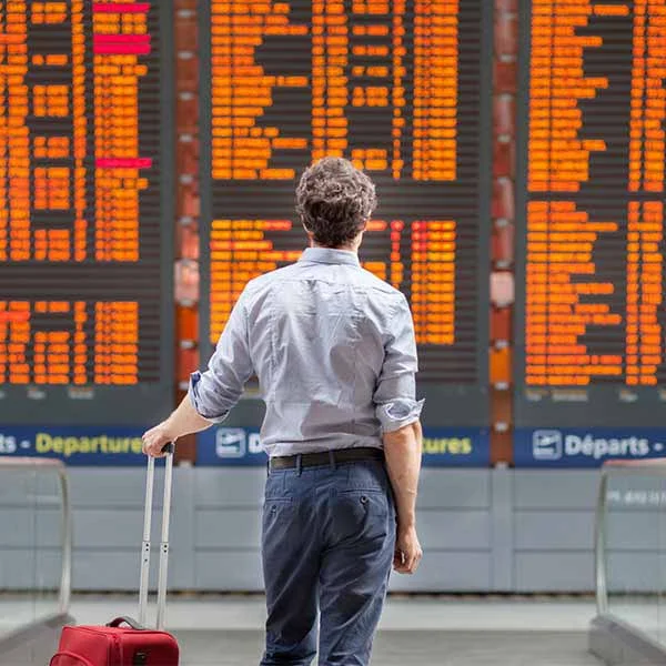 business man in airport looking at cancelled flights