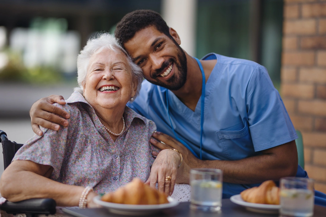 Caregiver having breakfast with his client at cafe