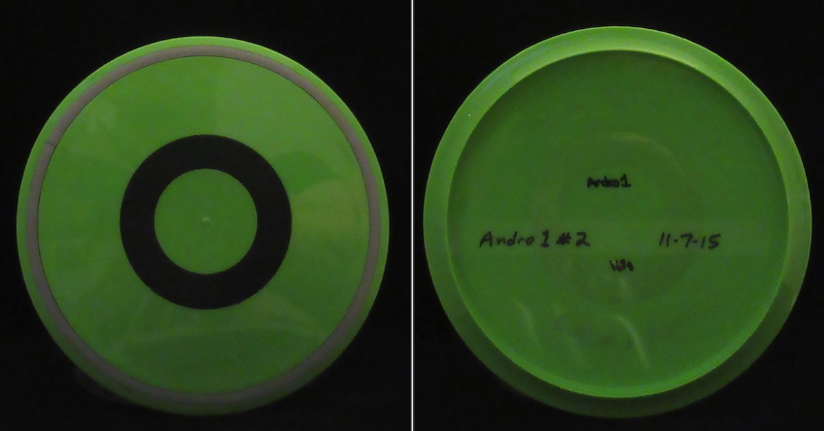 A green discs seen fromtop and bottom. The top has a blackring near its center.