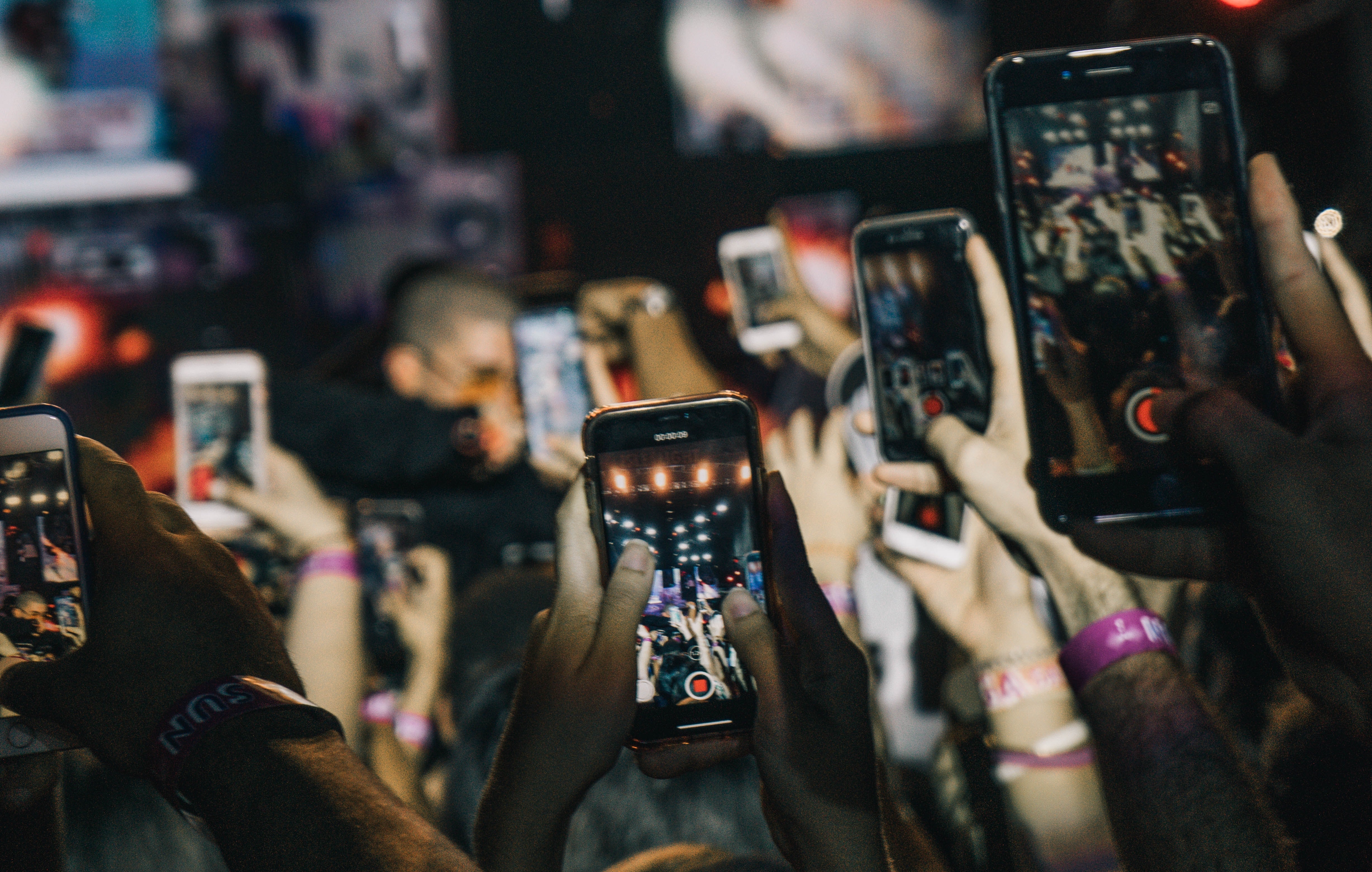 People holding up phones at concert