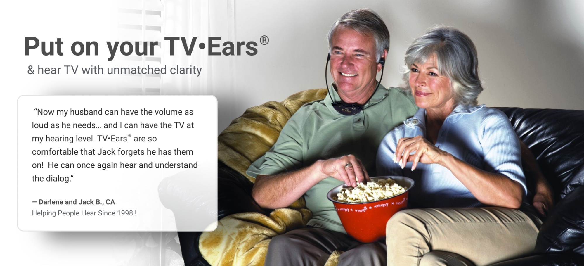 old couple eating popcorn and watching a movie while wearing TV Ears