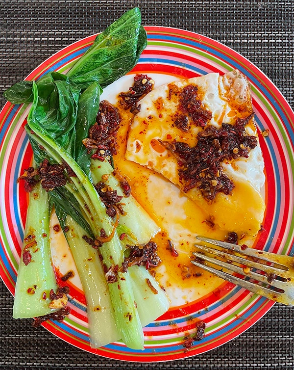 chili crisp oil on fried egg with bok choy breakfast sichuan fly by jing farmstead