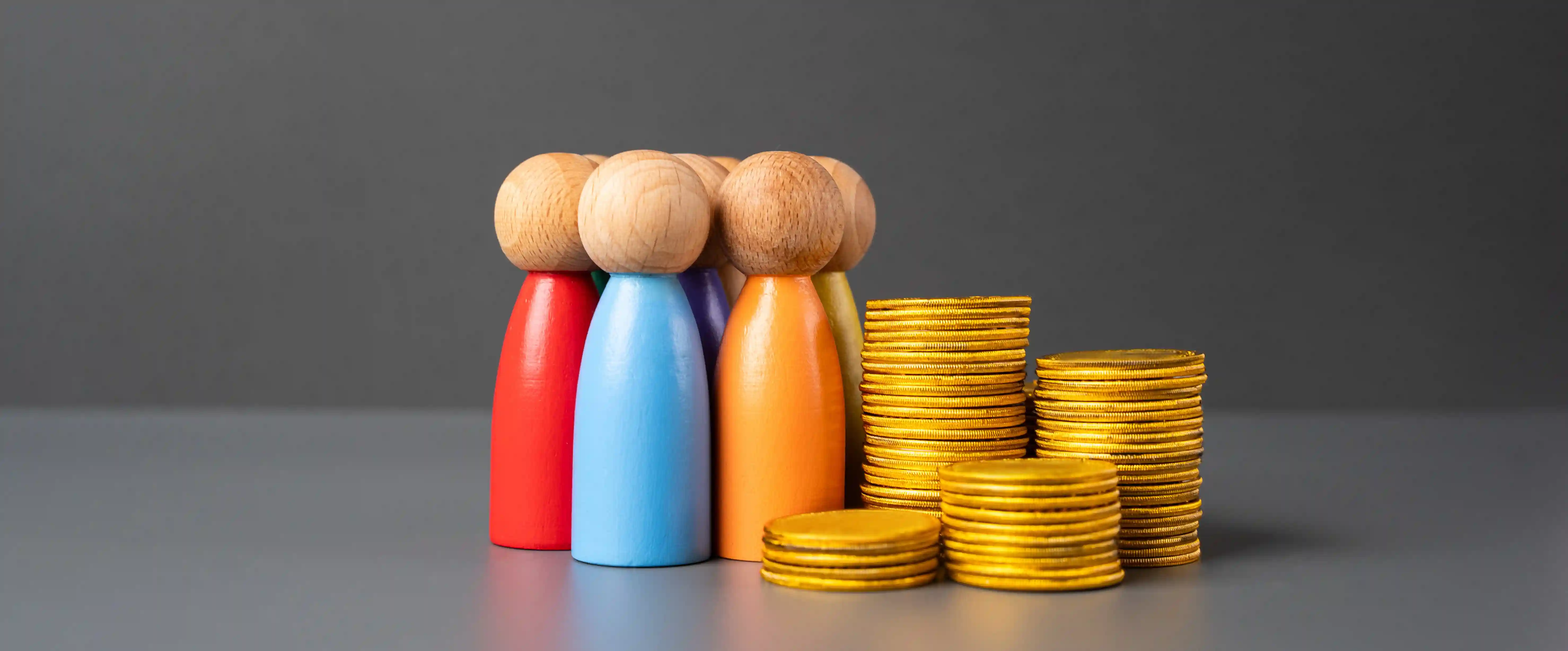 Colorful wooden figures with gold coin stacks representing fair pay and financial ROI of values-based recruitment