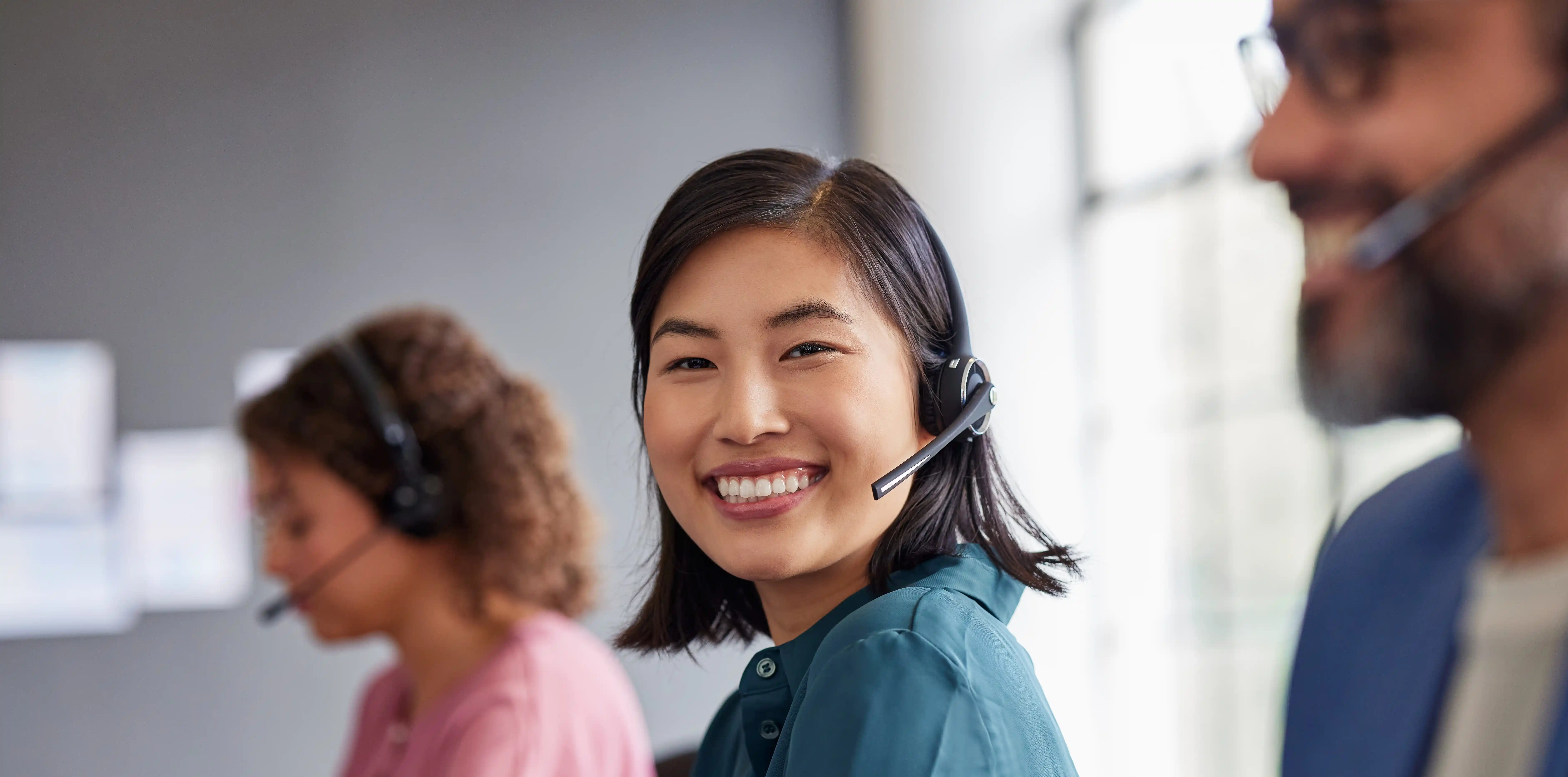 Smiling diverse customer support team with headsets representing ethical ESG-compliant managed teams