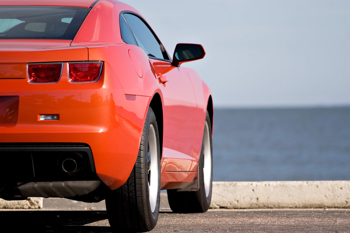 summer performance tires on a red sports car.webp